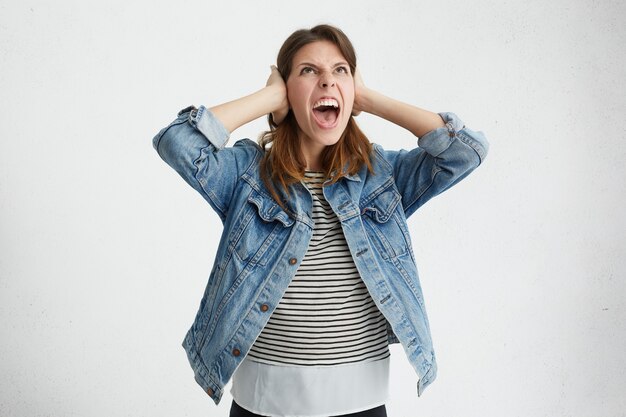 Annoyed female looking upwards with furious expression