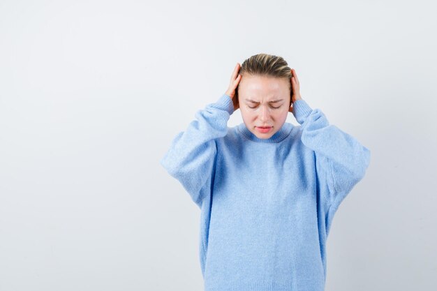 Annoyed girl closed her ears with  hands on white background