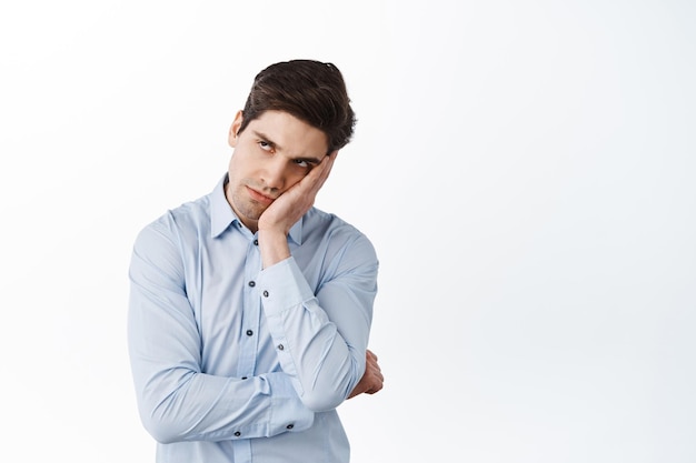 Annoyed office worker look aside with angry irritated face, lean on hand pissed-off, have under eye dark circles, standing bothered against white background