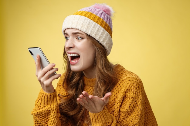 Free photo annoyed pissed freak-out crazy woman shouting smartphone look display near face irritated arguing boyfriend breaking-up via phone call standing angry furiously yelling cellphone, raise hand dismay