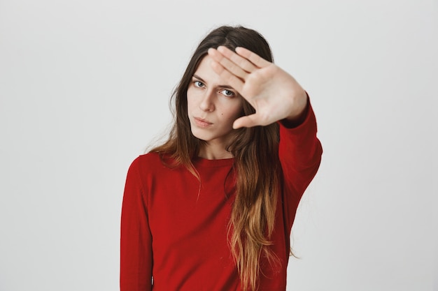 Free photo annoyed, pissed-off woman stretch hand in stop motion, unwilling being shot