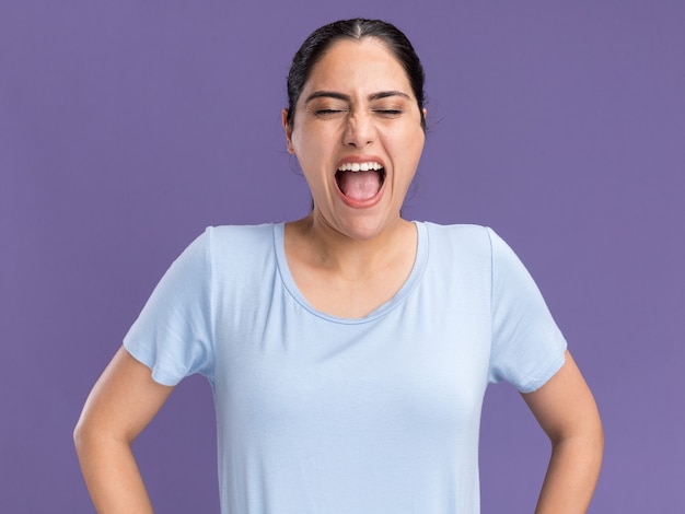 Annoyed young brunette caucasian girl yelling at someone on purple