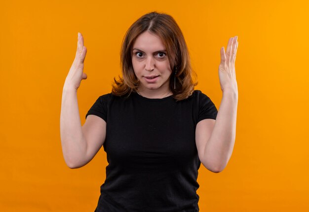 Раздраженная молодая случайная женщина с поднятыми руками на изолированном оранжевом пространстве
