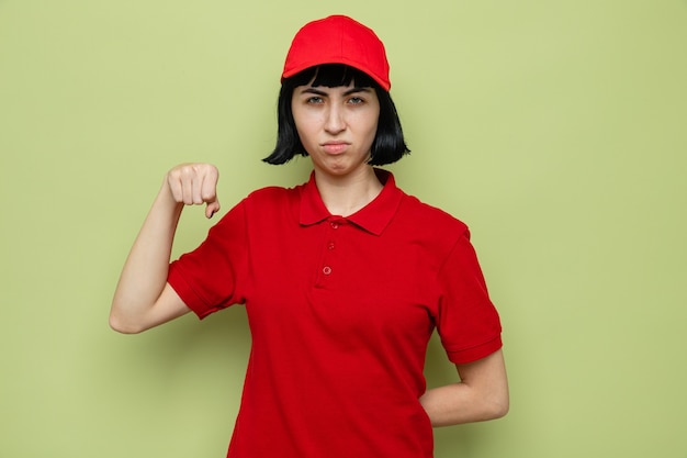 Annoyed young caucasian delivery woman keeping fist and looking 