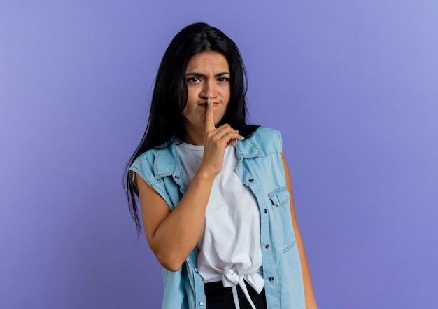 Annoyed young caucasian girl gestures silence sign isolated on purple background with copy space