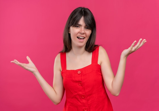 Annoyed young caucasian girl holds both hands up on isolated pink background