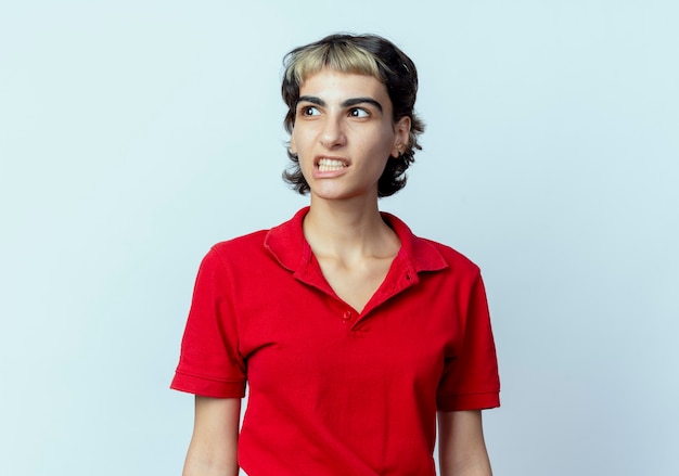 Annoyed young caucasian girl with pixie haircut looking at side isolated on white background with copy space