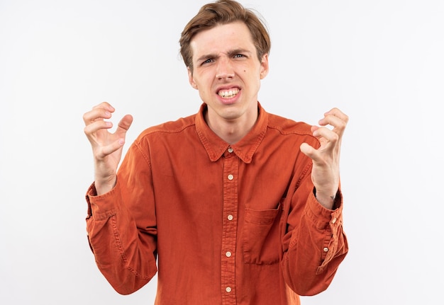 Annoyed young handsome guy wearing red shirt holding hands around face isolated on white wall