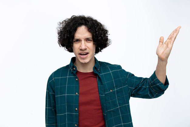 Annoyed young handsome man looking at camera showing empty hand isolated on white background