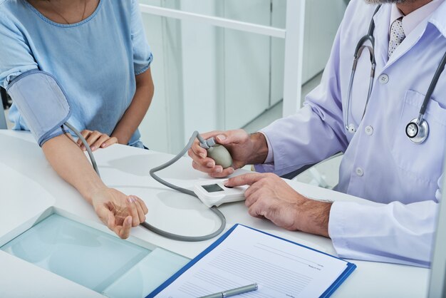 anonymous doctor measuring blood pressure to unrecognizable patient with a tonometer