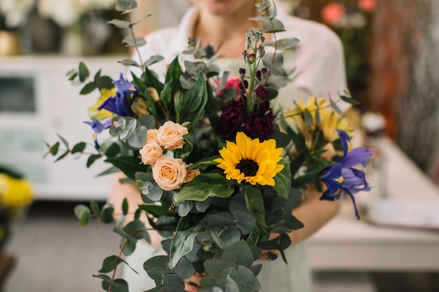 Anonymous florist holding bunch of flowers