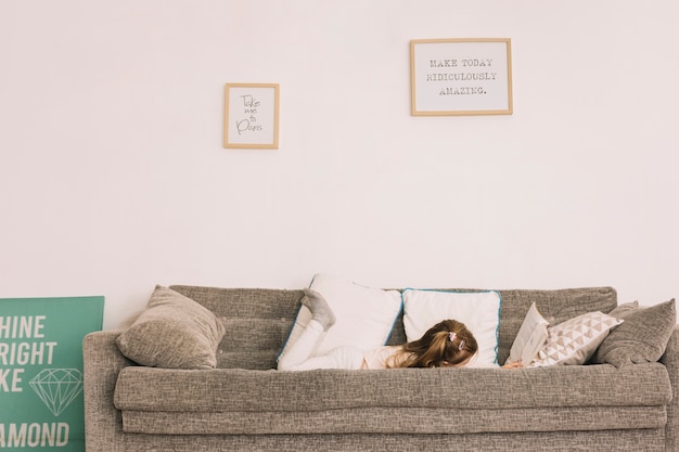 Free photo anonymous girl reading on sofa