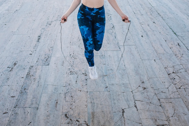 Anonymous girl training with jumping rope