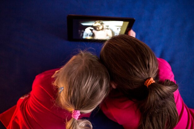 Free photo anonymous girls watching video on tablet