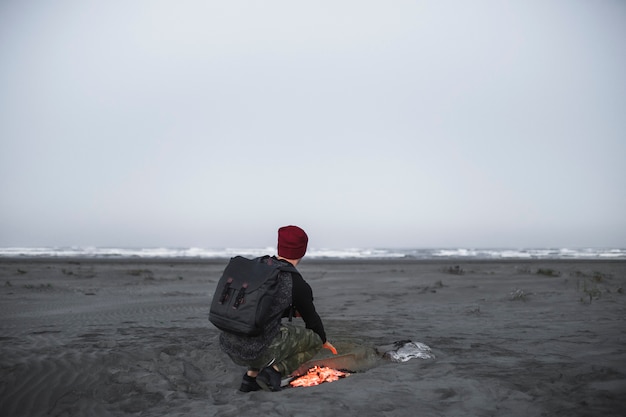 Anonymous man warming near fire