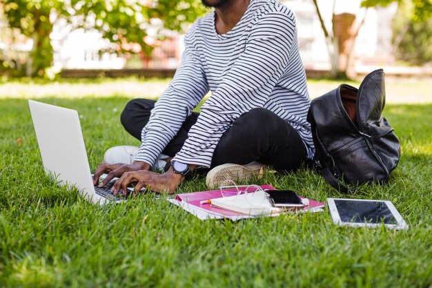 Anonymous man with computer in park