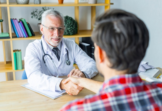 Anonymous patient shaking hand of doctor