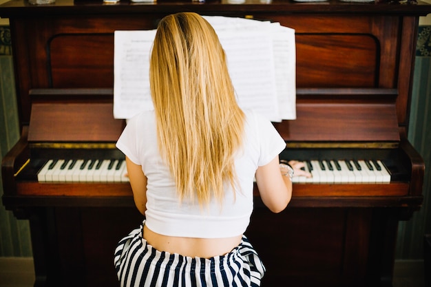 Foto gratuita anonima donna che suona il pianoforte