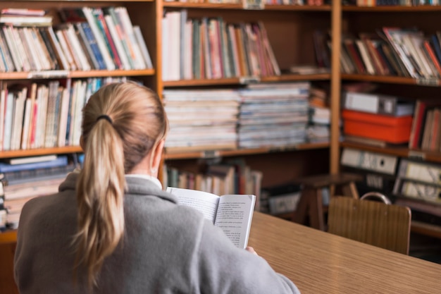 Free photo anonymous woman reading in library