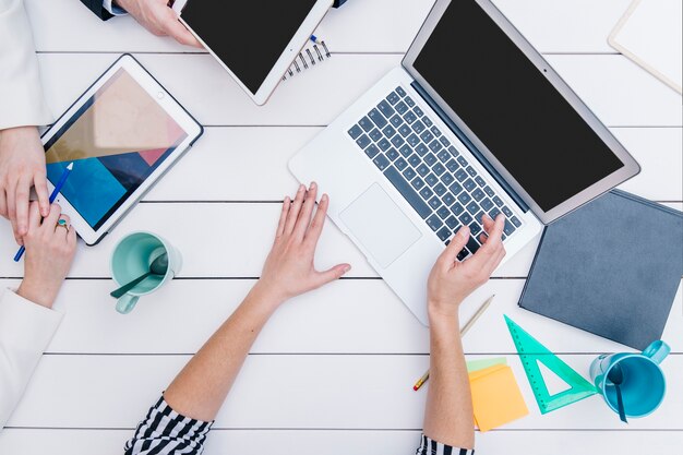 Anonymous woman showing laptop to colleagues