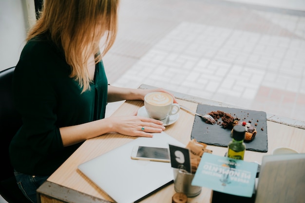 Anonymous woman with coffee in cafe