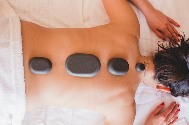 Anonymous woman with massage stones