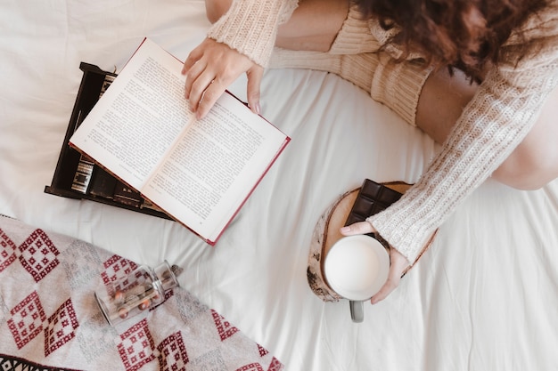 Free photo anonymous woman with milk reading book