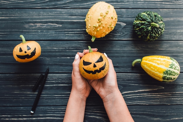 Foto gratuita donna anonima con zucche per halloween