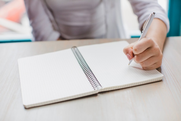 Anonymous woman writing in notepad