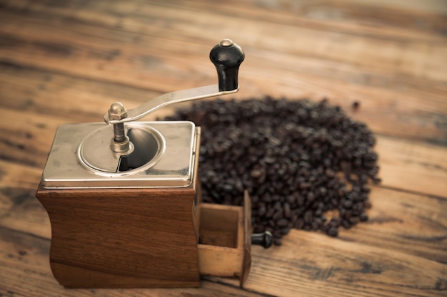 Antique coffee grinder with coffee beans behind