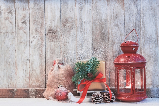 Free photo antique lamp with a gift to the side and pine cones