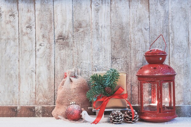 Antique lamp with a gift to the side and pine cones