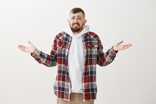 Anxious clueless man shrugging and panicking from being unaware