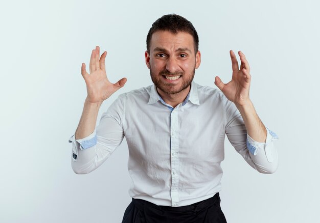 Anxious handsome man raises hands looking isolated on white wall