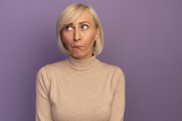 Foto gratuita la donna slava abbastanza bionda ansiosa guarda a lato sulla porpora