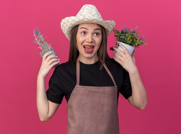 側を見て植木鉢を保持しているガーデニング帽子をかぶっている気になるかなり白人女性の庭師