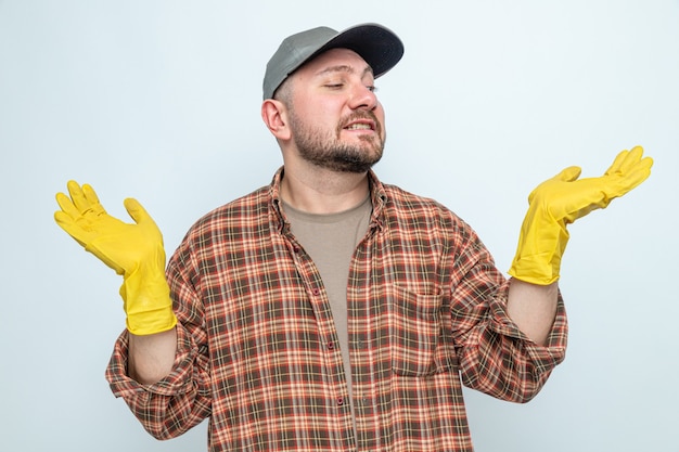 Anxious slavic cleaner man with rubber gloves keeping hands open and looking at side 