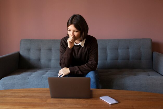 Anxious woman sitting on couch front view