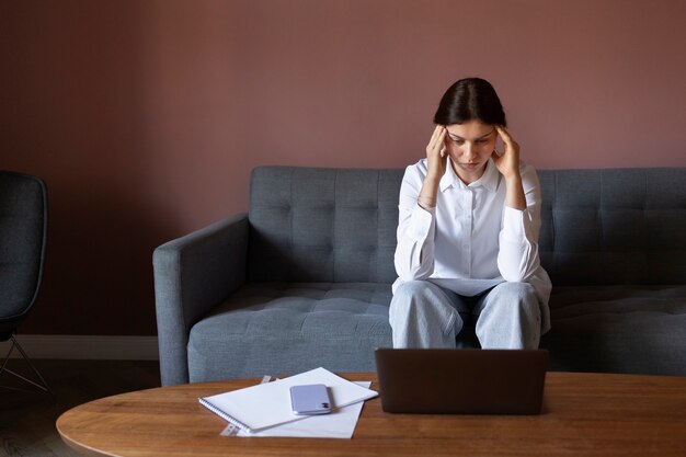 Anxious woman sitting on couch front view