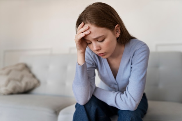 Free photo anxious woman sitting at home front view