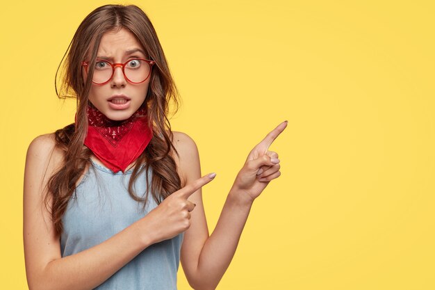 Anxious worried young woman with dark messy hair, has frustrated expression