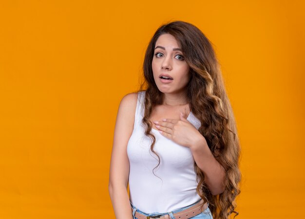 Anxious young beautiful girl putting hand on chest on isolated orange space with copy space