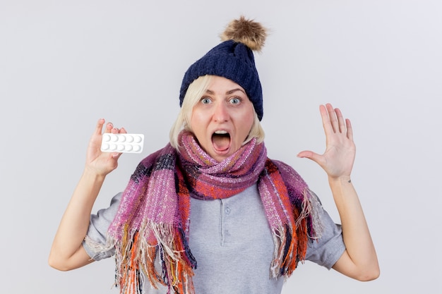 Anxious young blonde ill slavic woman wearing winter hat and scarf