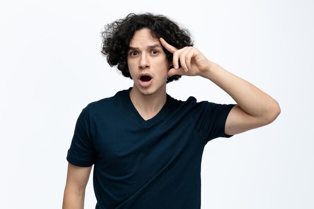 Anxious young handsome man looking at camera keeping hand on head isolated on white background