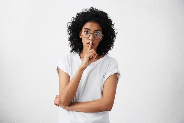 Anxious young mother with dark skin and black curly hair dressed casually