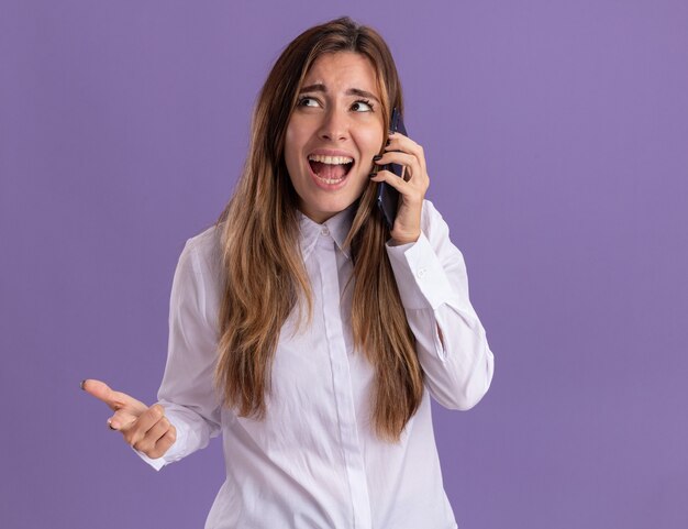 Anxious young pretty caucasian girl talks on phone and looks at side