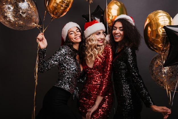 Appealing blonde woman in red dress celebrating winter holidays with friends