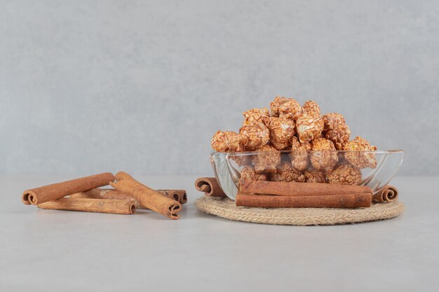 Appetizer bowl next to a bundle of cinnamon cuts on marble table.