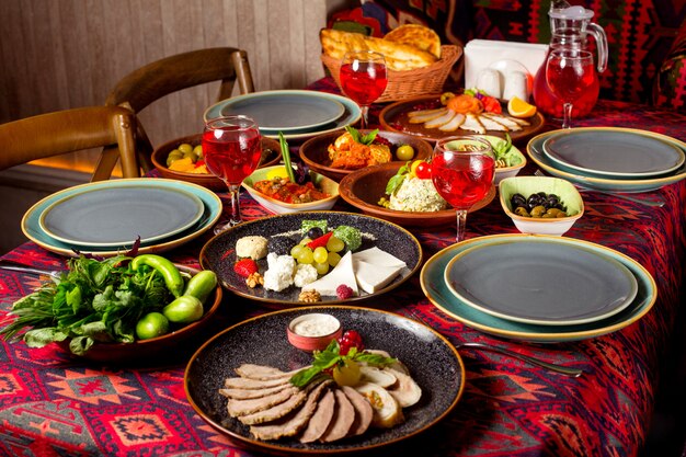 Appetizer set with meat and cheese plates, fresh mangal and olivier salads