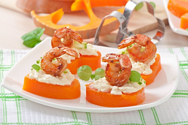 Appetizer of shrimp and cream cheese on pumpkin hearts